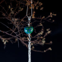 Green pendant with blue glass patterns and chain tassel on long chain. - Image 5