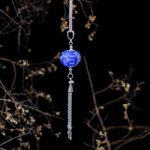 Indigo blue pendant with transparent glass patterns and chain tassel on long chain.