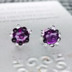 Magenta color stud earrings with clear bumps