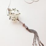 Transparent pendant with silver glass ornaments and chain tassel on a long chain